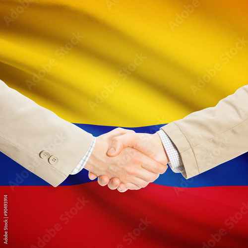 Businessmen handshake with flag on background - Colombia