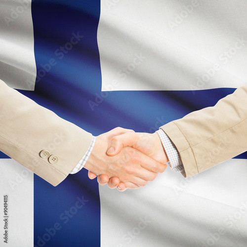 Businessmen handshake with flag on background - Finland