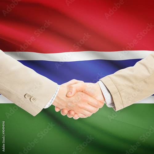 Businessmen handshake with flag on background - Gambia