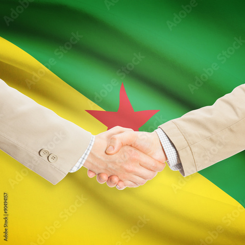 Businessmen handshake with flag on background - French Guiana photo