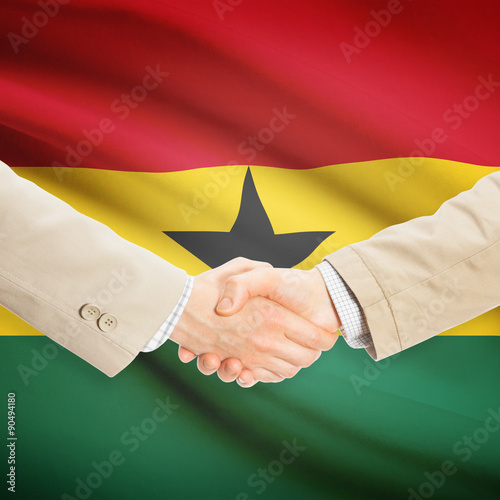 Businessmen handshake with flag on background - Ghana