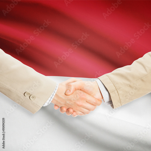 Businessmen handshake with flag on background - Indonesia