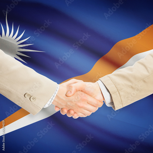 Businessmen handshake with flag on background - Marshall Islands