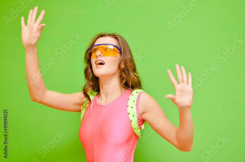 Bilde på lerret Woman wearing lycra jumpsuit and protect glasses on green