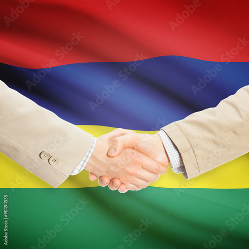 Businessmen handshake with flag on background - Mauritius