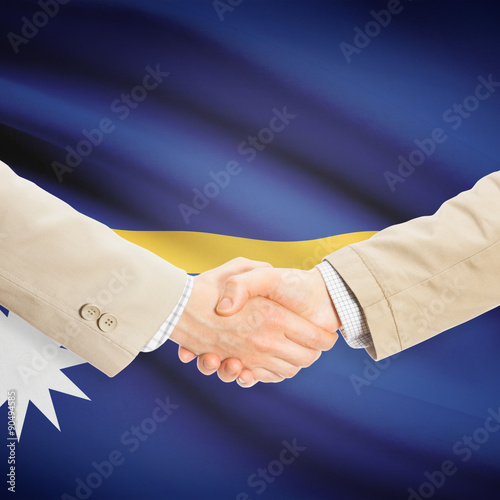 Businessmen handshake with flag on background - Nauru