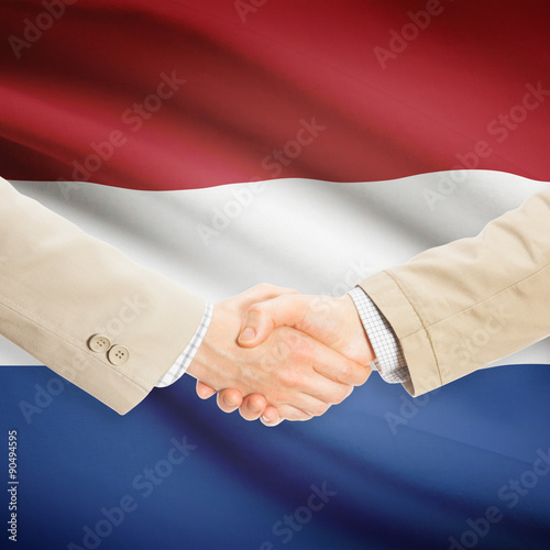Businessmen handshake with flag on background - Netherlands
