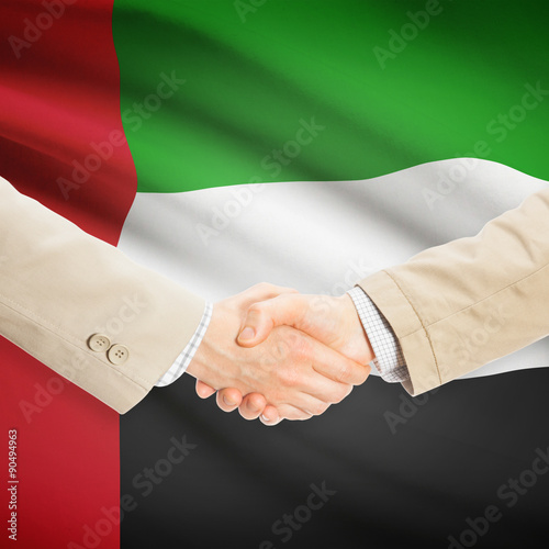 Businessmen handshake with flag on background - United Arab Emir