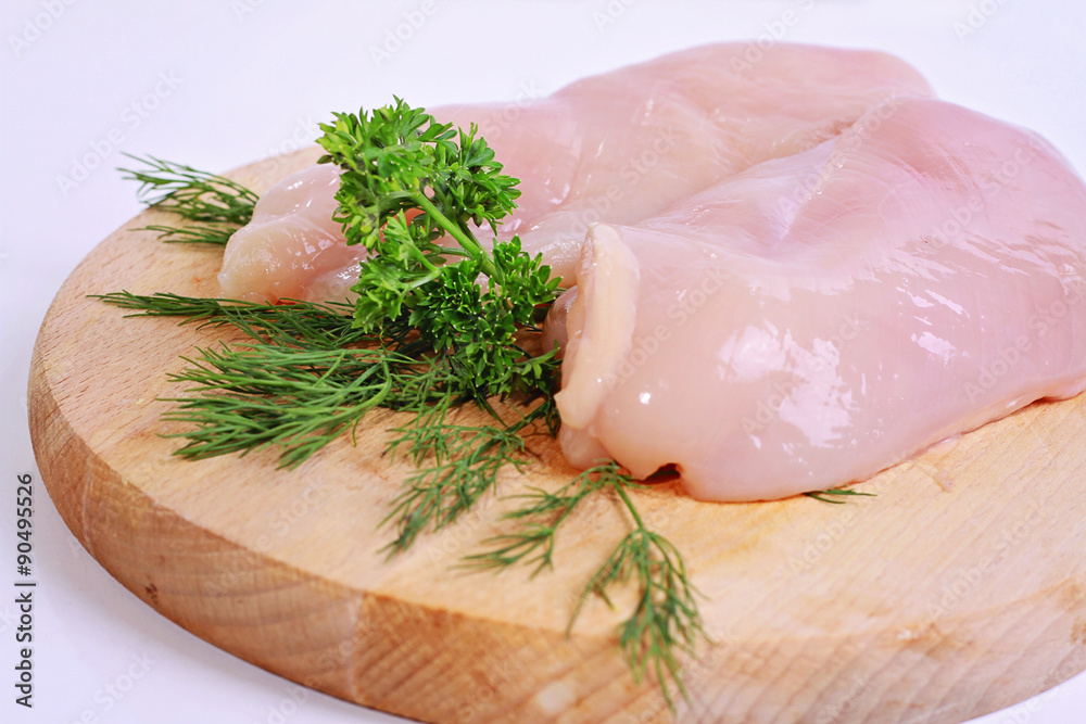 Raw chicken breast fillets  on wooden cutting board