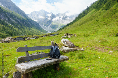 Tableau sur toile Rucksack auf der Rastbank in den Alpen