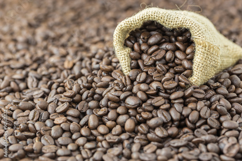 coffee beans in sack bag on wooden background © hatchapong