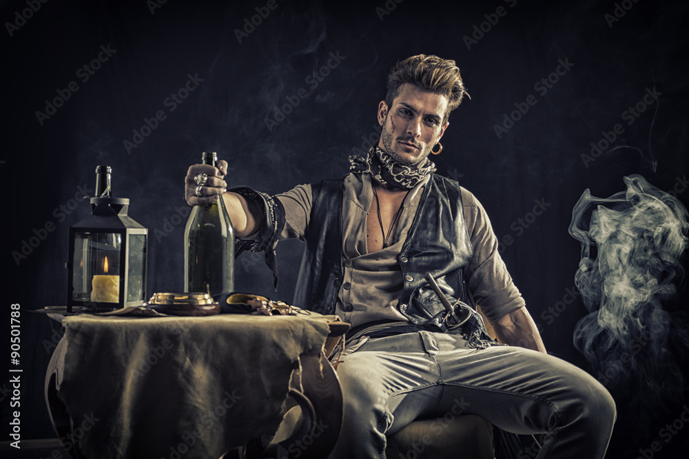 Fototapeta premium Przyglądający młody człowiek w stroju pirata mody siedzi obok