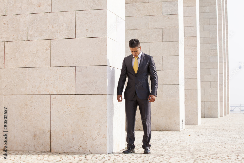 Fototapeta premium Sad businessman relaxing next to some wall