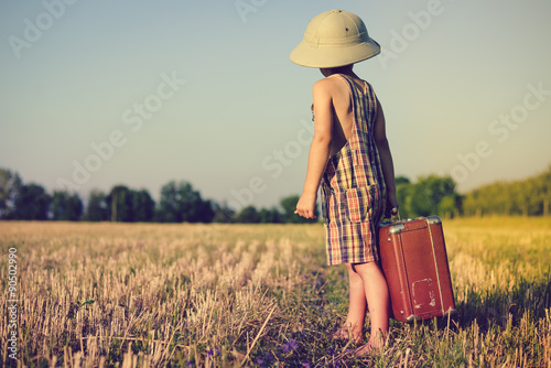 Canvas Print Little boy wearing plaid romper and pith helmet carrying big
