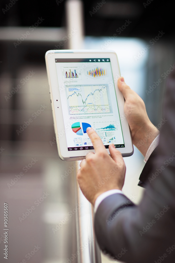 Business person analyzing financial statistics displayed on the tablet screen