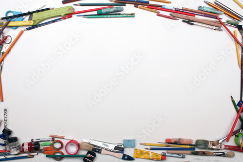 Art supplies border on white table with space for text