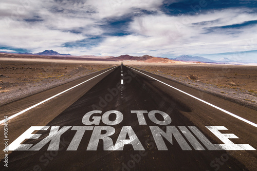 Go To Extra Mile written on desert road photo