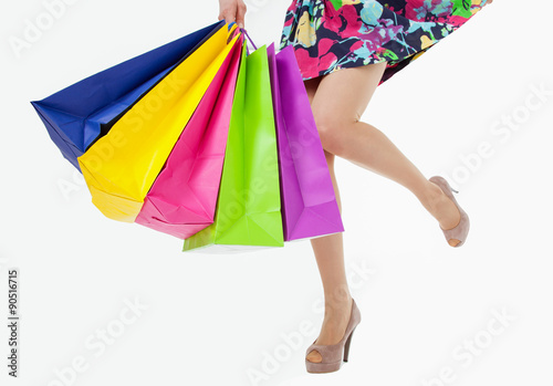 Happy young woman with multicolored shopping bags