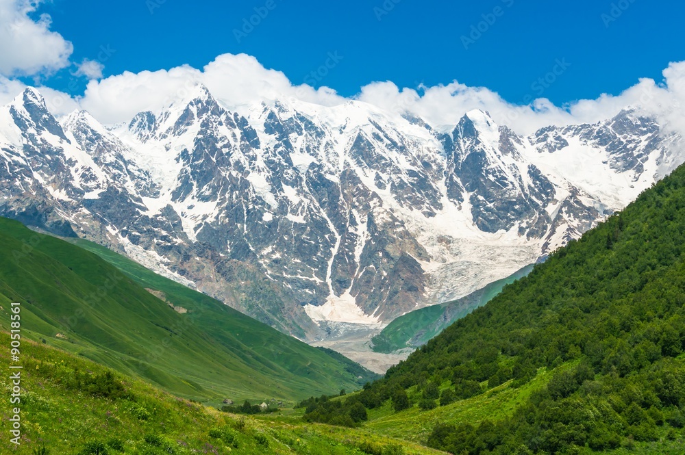 Beautiful grassy valley and snow-capped mountains in Georgia