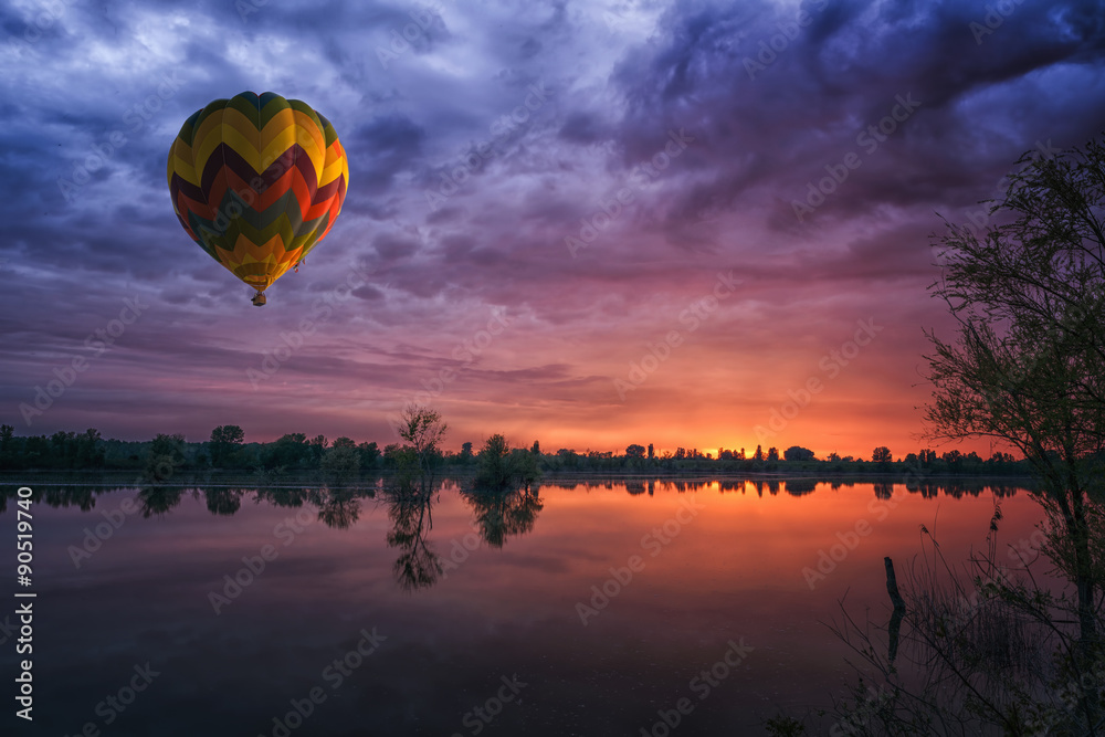 Fototapeta premium hot air balloon at sunset at the lake landscape natural background