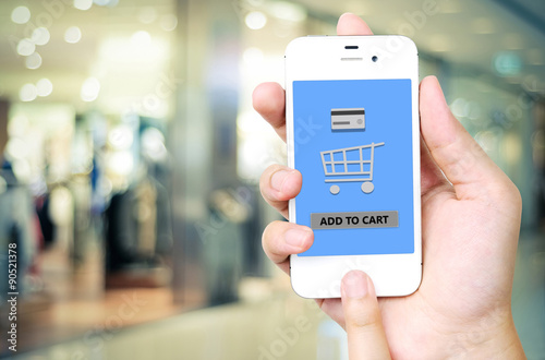 Hand holding smart phone with add to cart words on screen over b