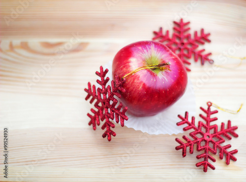 Apple with snowflakes on wooden texture 