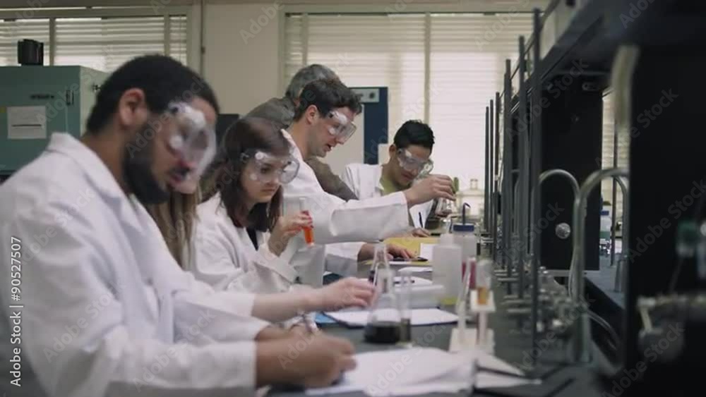 A professor helps his students with their science experiments
A professor helps his students with their science experiments