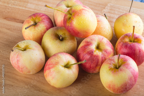wet fuji apple on wood chop block and on wood table