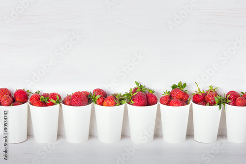 a series of white paper cups with fresh ripe delicious sweet str
