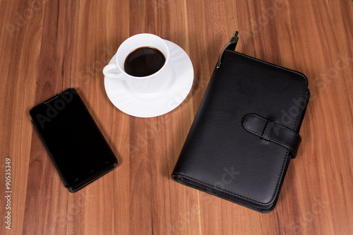 Cup of coffee,phone and notebook