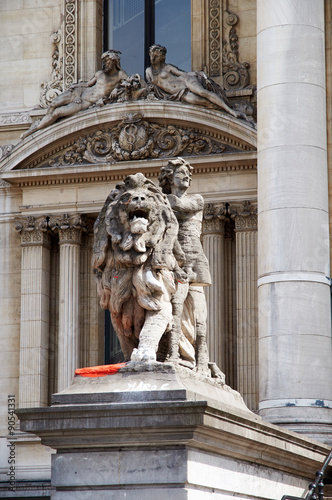 Statue of a man and a lion, facade of the Brussels stock-exchange.