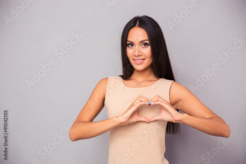 Foto Beautiful woman making heart with fingers