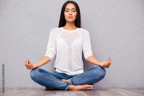 Pretty woman meditating on the floor