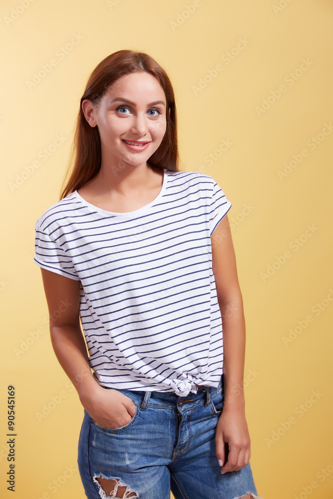 Obraz premium the red-haired beautiful young girl smiles on a yellow backgroun