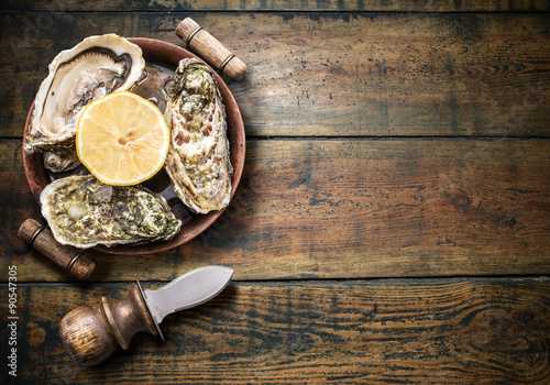 Raw oysters on the old wooden table.