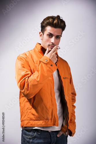 Handsome young man smoking cigarette, dressed as James Dean