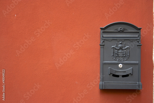grey mailbox on a red wall