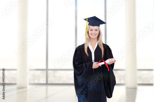 Smiling blonde student in graduate robe holding her degree