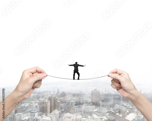 Businessman balancing on tightrope with woman two hands holding