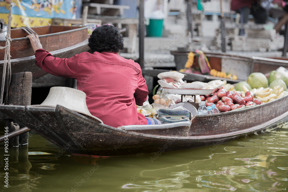 Obraz premium Woman vendor sell friut on boat in floating market