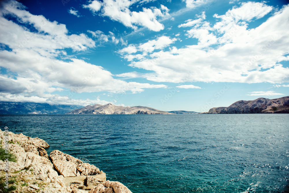 Scenic seaside landscape with cliffs and ocean waves, calm water and cloudy skies.Soft vintage effect on photo. Traveling concept