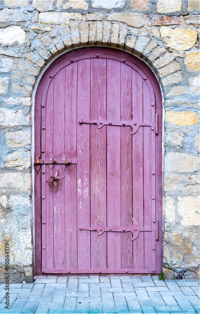 Fototapeta premium Ancient wooden door in old stone wall.