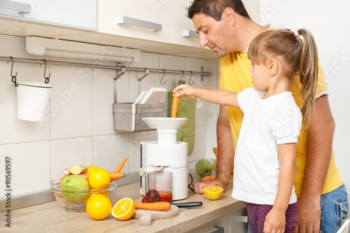 Father and daughter having fun and mixing fresh vegetables for breakfast in the kitchen
