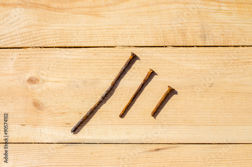 Three nails on a wooden table