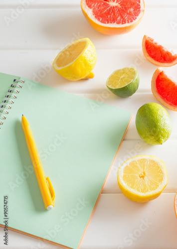 citrus with notebook on white wooden table