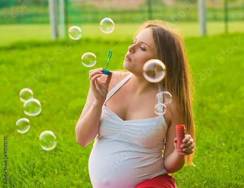 Happy pregnant woman with bubbles