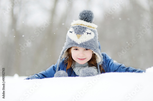 Funny little girl having fun in winter park