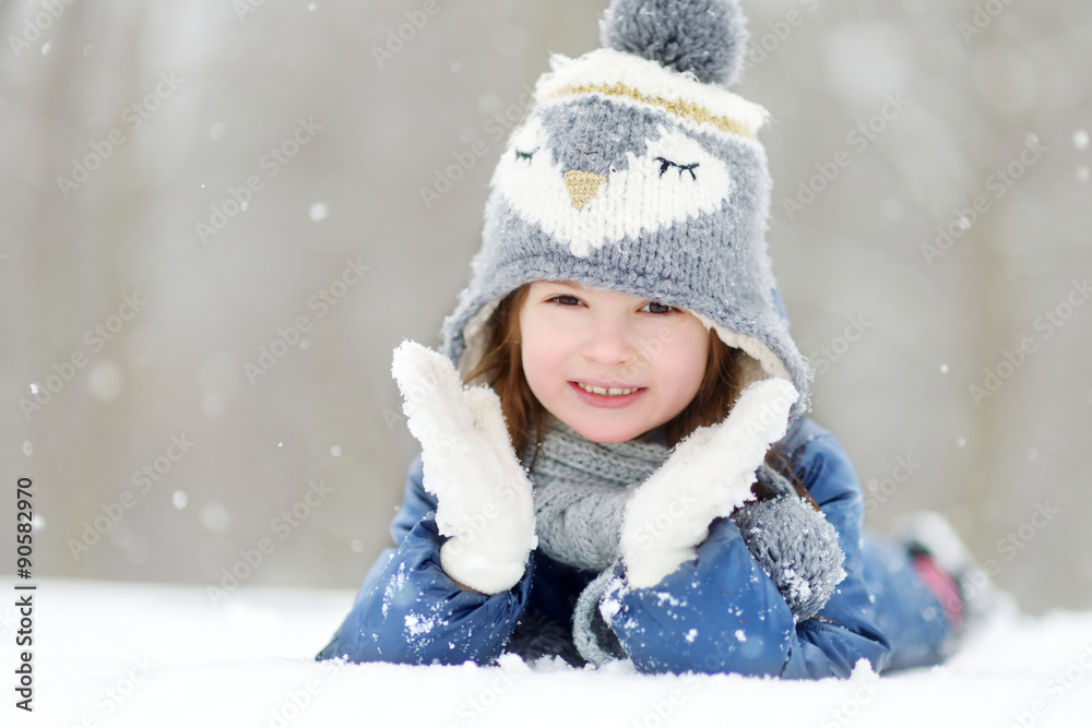 Funny little girl having fun in beautiful winter park during snowfall Funny little girl having fun in beautiful winter park during snowfall