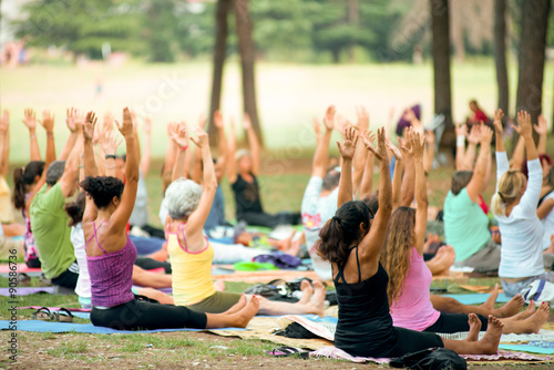 people doing yoga in a park at sunset