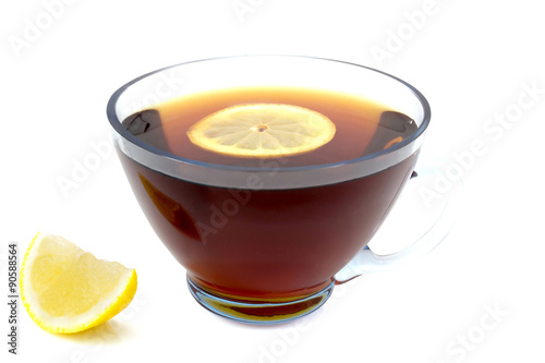 transparent cup of tea with a slice of lemon and whole lemon left isolated on white background 